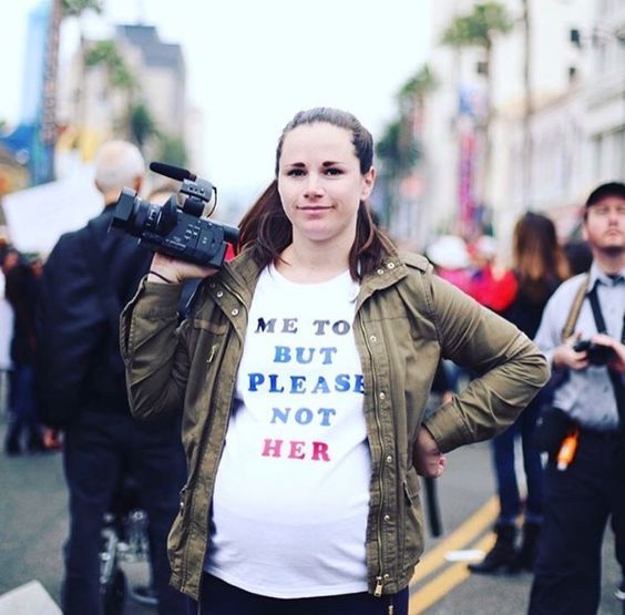 a pregnant woman in a march with a white t-shirt with the phrase "me to but please not her"