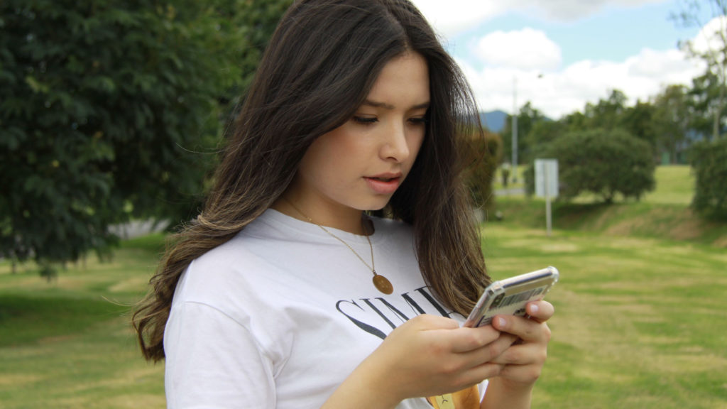 young woman reading messages on phone